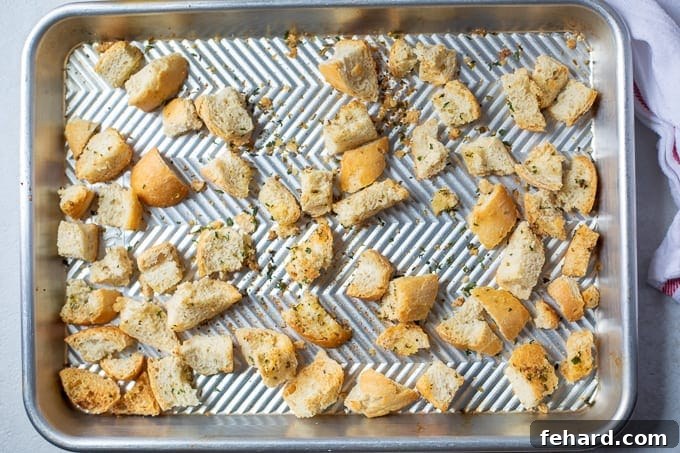A baking sheet filled with golden, crispy homemade croutons, fresh out of the oven and perfectly browned.