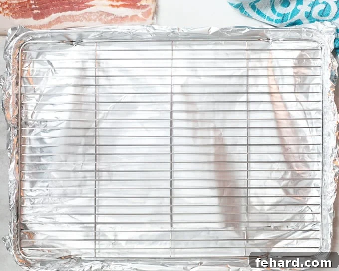 Rimmed Baking Sheet lined with foil and topped with a wire rack, ready for bacon.