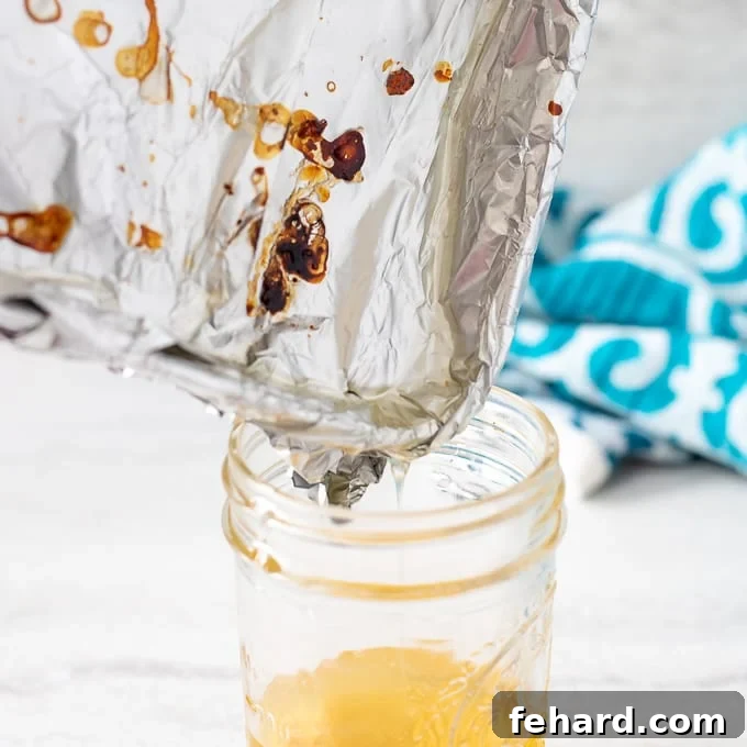 Bacon grease being poured into a glass jar for safe disposal.