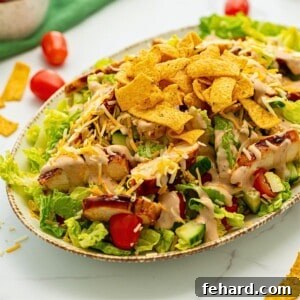 Platter with bed of lettuce topped with BBQ Chicken, shredded cheese, corn chips, and BBQ Ranch Dressing.