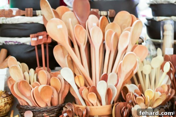 A display of handmade wooden spoons of varying sizes in terra cotta pots and baskets. 