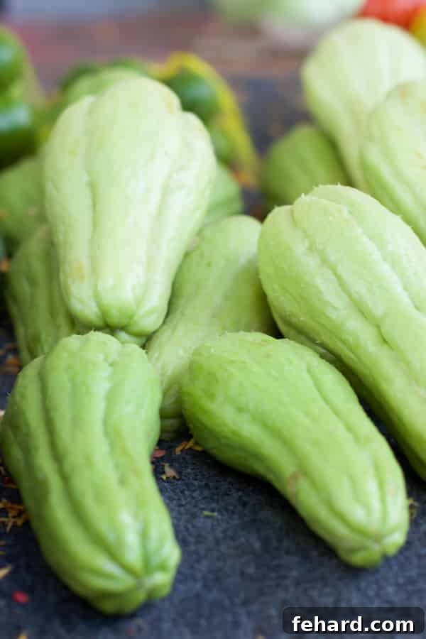 A stack of green chuchu vegetables in a farmers' market stand. 