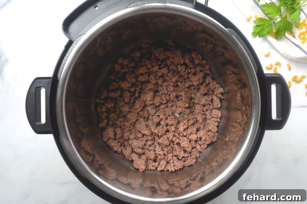 Instant Pot Hamburger Helper with Beef Browned ground beef inside inner pot.