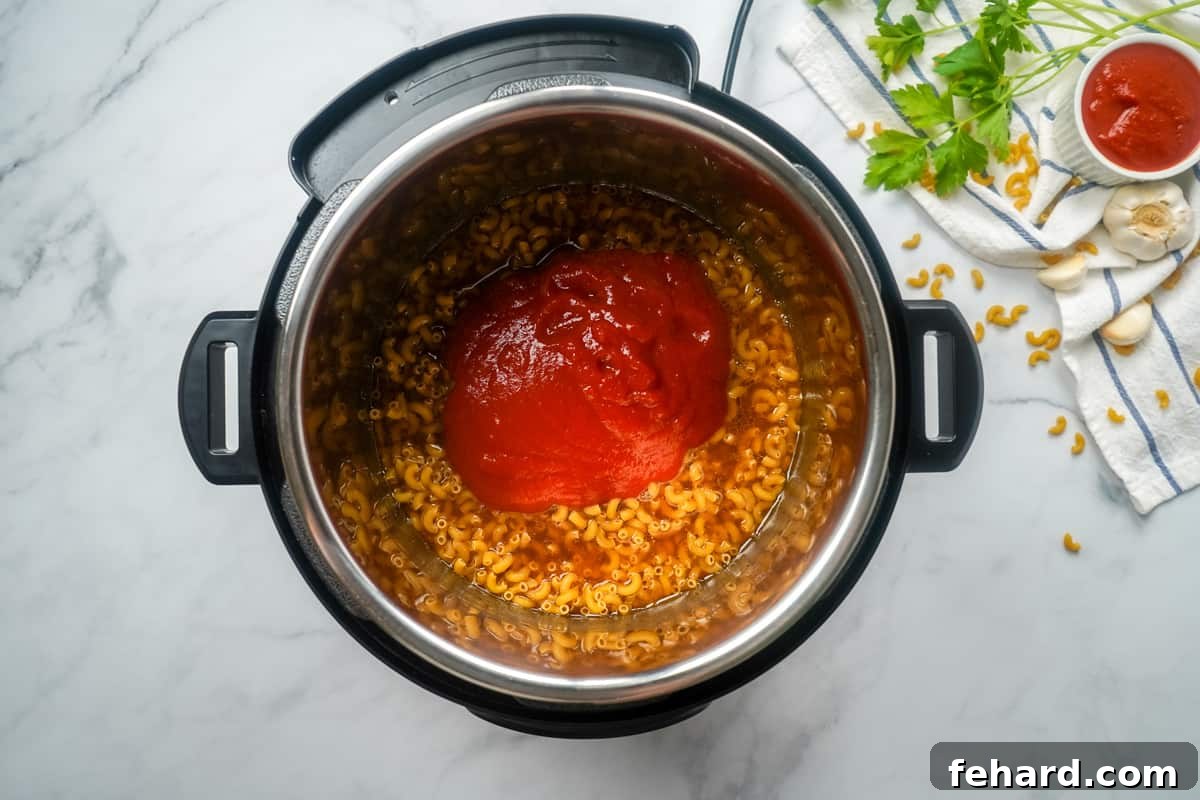 How to Make Hamburger helper in Instant Pot Ingredients for Hamburger helper layered inside inner pot of Instant Pot.