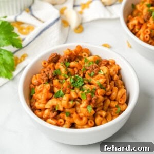 Instant Pot Hamburger Helper served in white bowl topped with parsley.