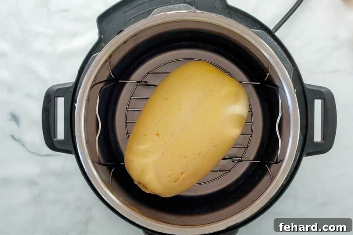 Instant Pot Spaghetti Squash Recipe Whole spaghetti squash sitting on trivet inside inner pot.