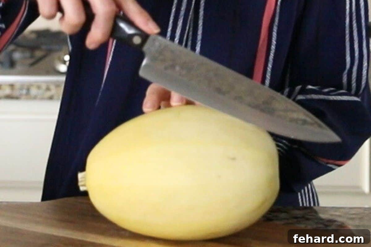 Spaghetti Squash Pressure Cooker Knife running lengthwise across a spaghetti squash to make spaghetti boats.