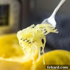 Fork scooping out perfectly cooked spaghetti squash from squash next to Instant Pot.