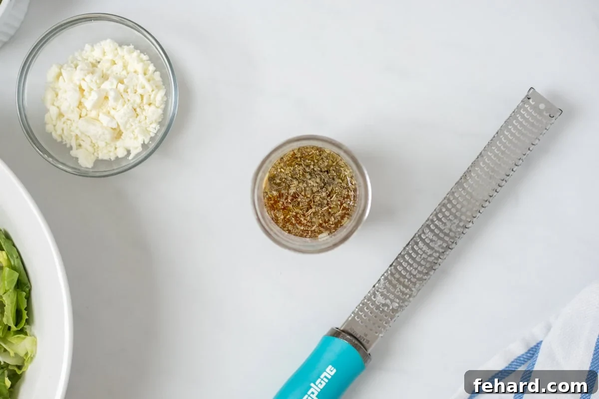 Homemade Panera Greek Vinaigrette A small ball jar filled with homemade copycat Panera Greek dressing, vibrant and slightly emulsified, sitting next to a microplane for grating fresh garlic.