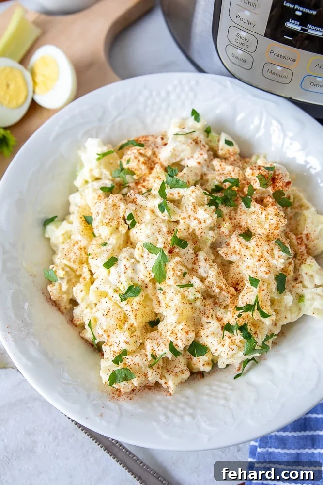 Instant Pot Potato Salad - The Ultimate Guide A beautifully presented bowl of creamy Instant Pot Potato Salad, garnished with fresh chives, beside a gleaming Instant Pot pressure cooker. The scene suggests deliciousness made with modern convenience.