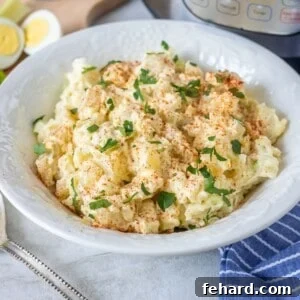 Bowl of Instant Pot Potato Salad with instant pot in background.