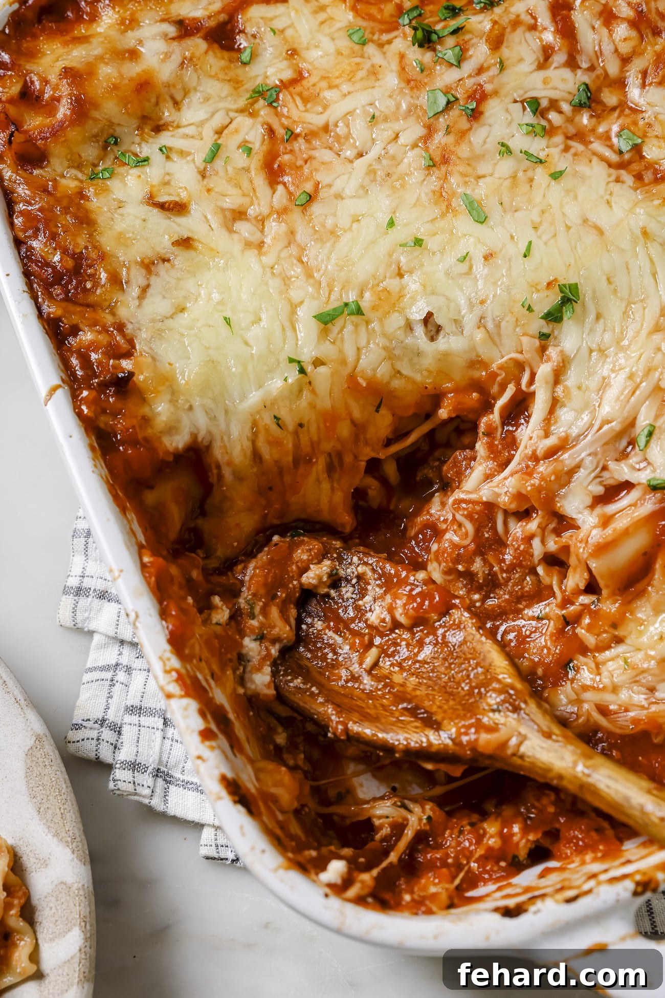 A casserole dish of lasagna rolls with a serving taken out. 