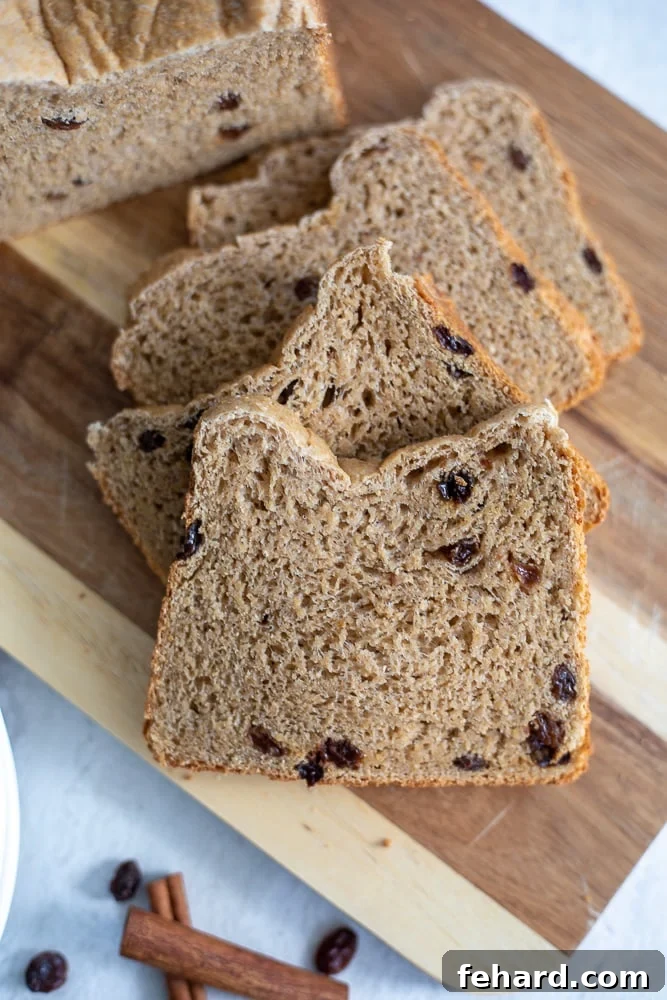 Cinnamon Raisin Bread Slice of cinnamon raisin bread with a pat of butter on wooden cutting board