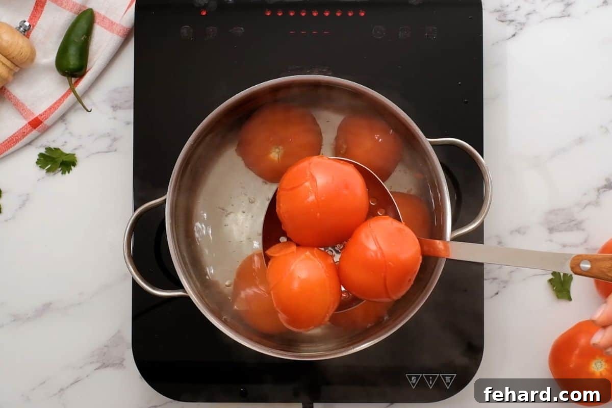 Speedy Blender Salsa 5 Slotted spoon carefully pulling blanched tomatoes from boiling water, ready for an ice bath to remove skins easily.