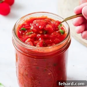 A bowl of homemade tomato sauce with fresh basil, ready to be served or stored.