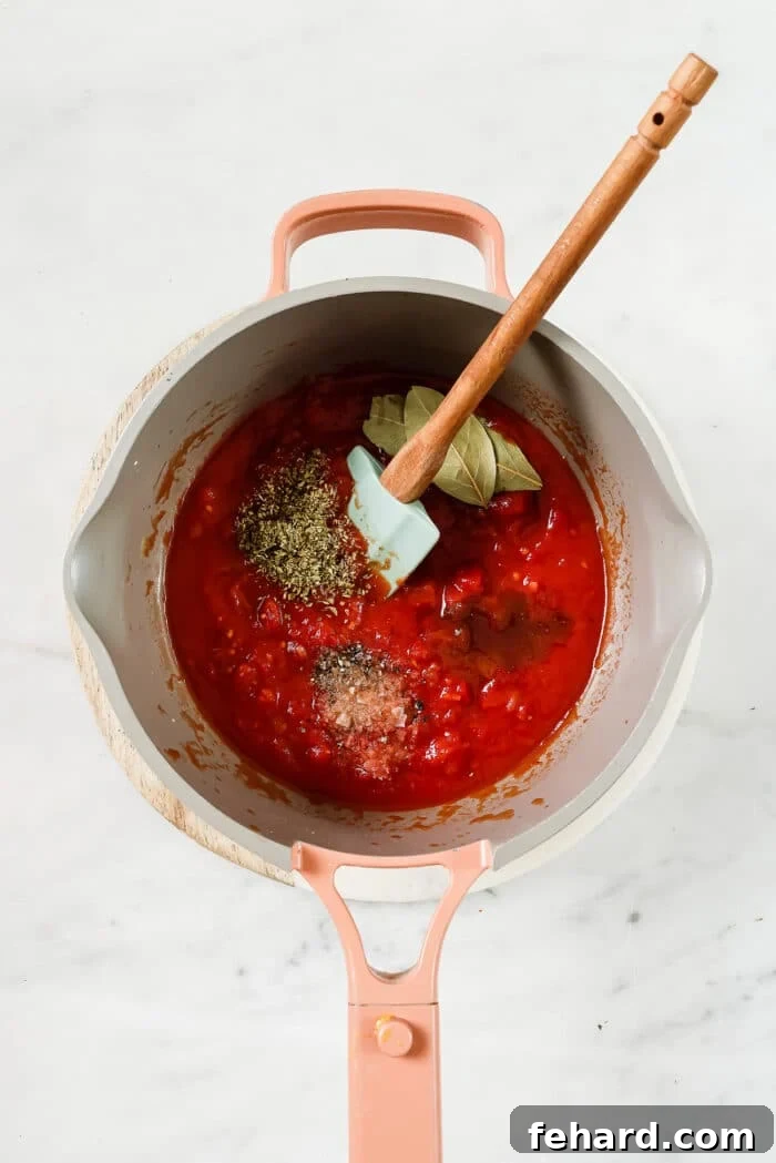 The Secret to Perfect Homemade Tomato Sauce 5 A mix of San Marzano tomatoes, brown sugar, oregano, bay leaves, salt, and pepper added to the pan, ready to simmer into a delicious sauce.