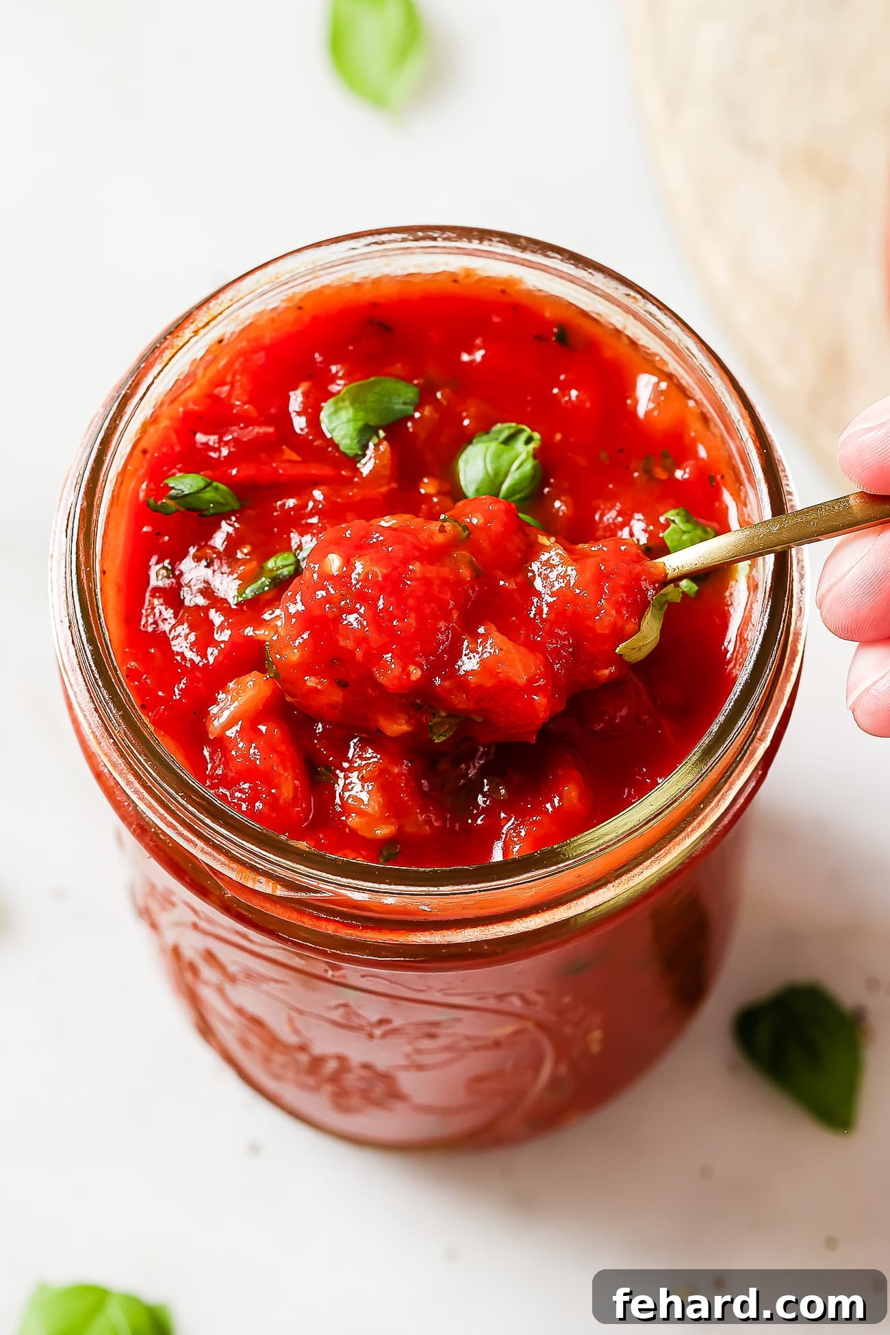 The Secret to Perfect Homemade Tomato Sauce 9 A close-up view of the rich, red homemade tomato sauce stored within a clear mason jar, highlighting its vibrant color and smooth texture.