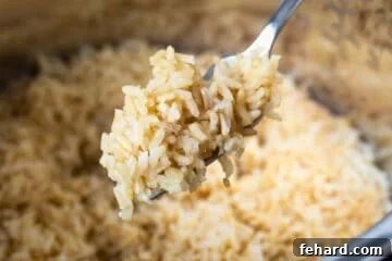 Fork with fluffed Instant Pot Brown rice showing it perfectly cooked and intact.