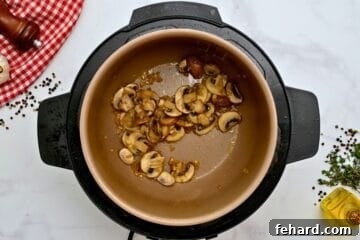 Sauteed mushrooms inside inner pot for Instant Pot Pork Chop recipe.