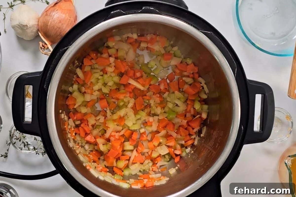 Carrots, onions, celery, and garlic sauteed in inner pot for base of ham and bean soup.