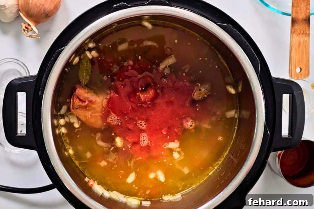 Ingredients for ham and bean soup layered in inner pot of Instant Pot.