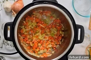 Carrots, onions, celery, and garlic sauteed in inner pot for base of ham and bean soup.