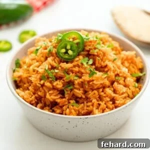 Bowl of fluffy Instant Pot Spanish Rice topped with cilantro and sliced jalapeno.