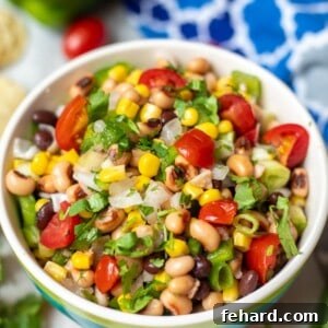 Bowl for Texas Caviar next to fresh peppers and tomatoes, highlighting key ingredients.