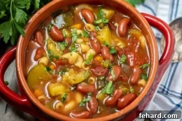 Red Bowl of Instant Pot Minestrone next to parsley.