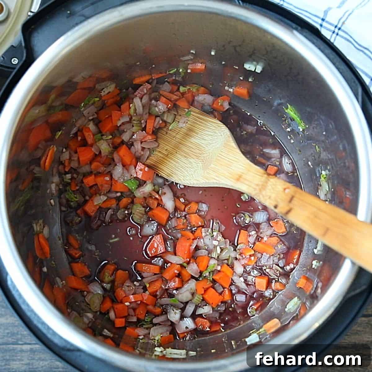 Red wine being poured into the inner pot of an Instant Pot, deglazing the bottom to release browned bits after sautéing vegetables.