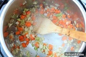 Onions, celery, and carrots sauteed in inner pot of instant pot.