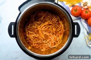Perfectly cooked tender noodles mixed in with meat sauce inside inner pot of pressure cooker.