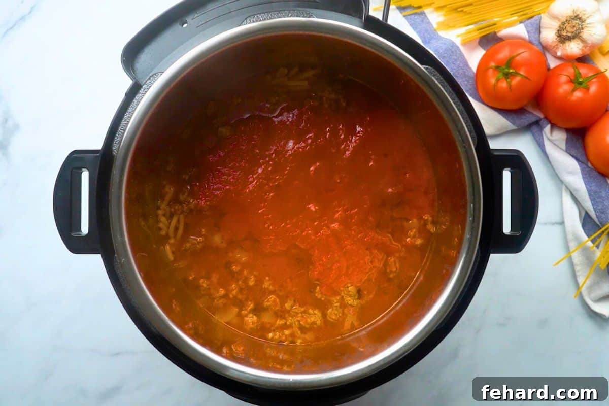 The Instant Pot immediately after the pressure cooking cycle, showing the noodles and sauce perfectly cooked and ready to be stirred.