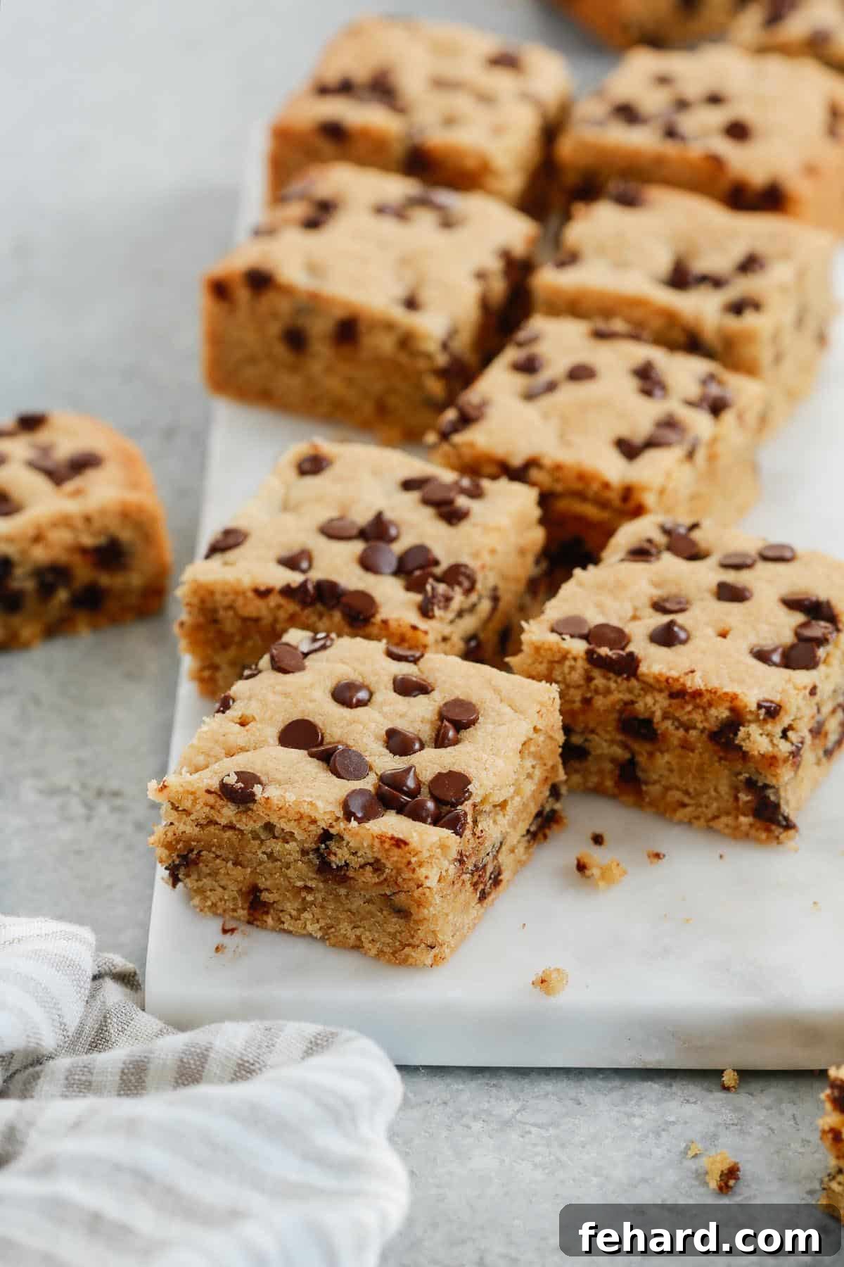 Close up of delicious chocolate chip cookie bars arranged on a marble serving board, ready to be enjoyed.