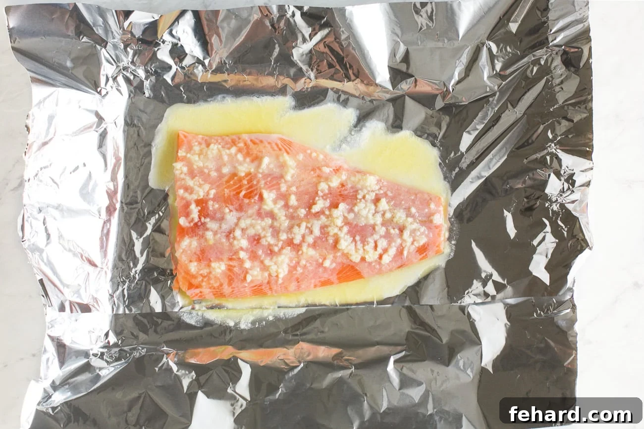 Salmon fillet placed on a baking sheet, generously coated with the melted butter mixture.