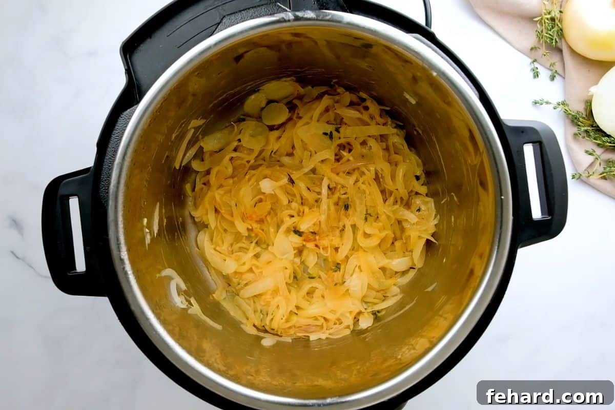 Perfectly caramelized onions and shallots, fragrant with thyme, glistening inside the Instant Pot's inner pot after being sautéed in butter and olive oil.