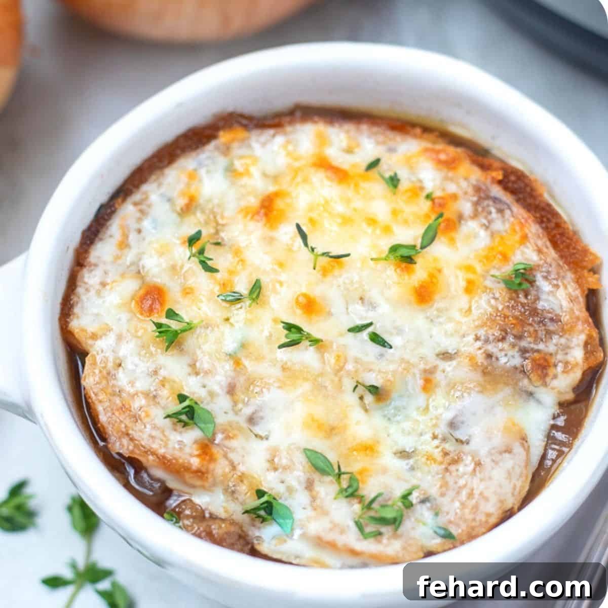 A beautifully presented bowl of French Onion Soup, garnished with fresh thyme, inviting you to enjoy its rich flavors.