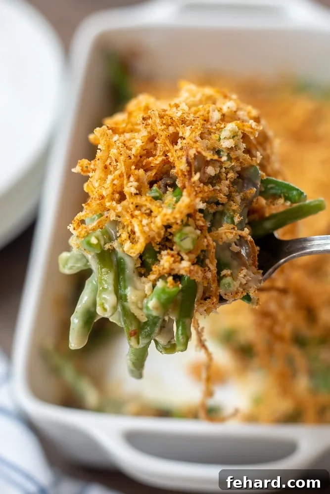 Homemade Green Bean Casserole being dished out onto large serving spoon.