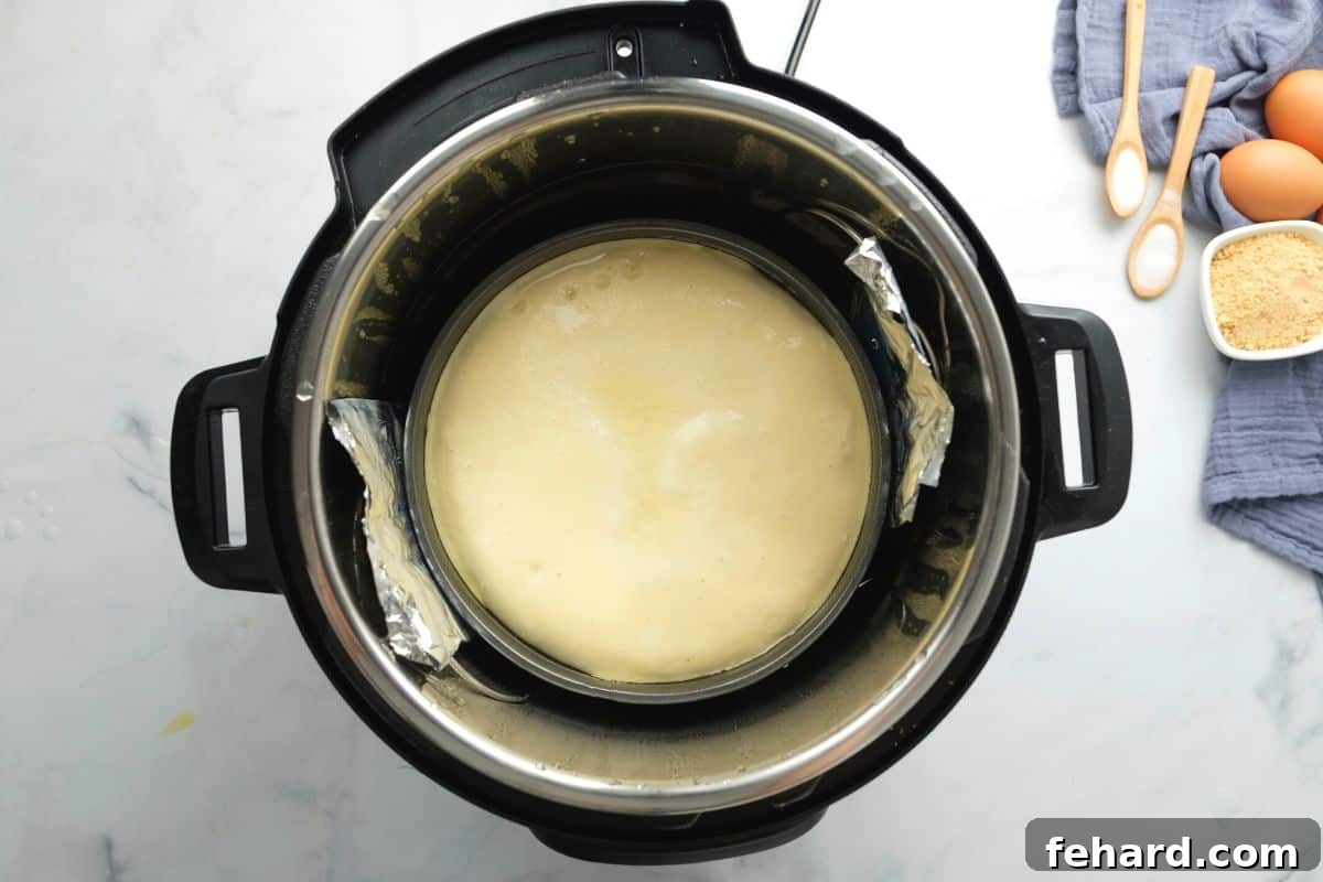 The perfectly baked Instant Pot Cheesecake resting inside the inner pot of the pressure cooker after cooking, indicating a successful natural release.