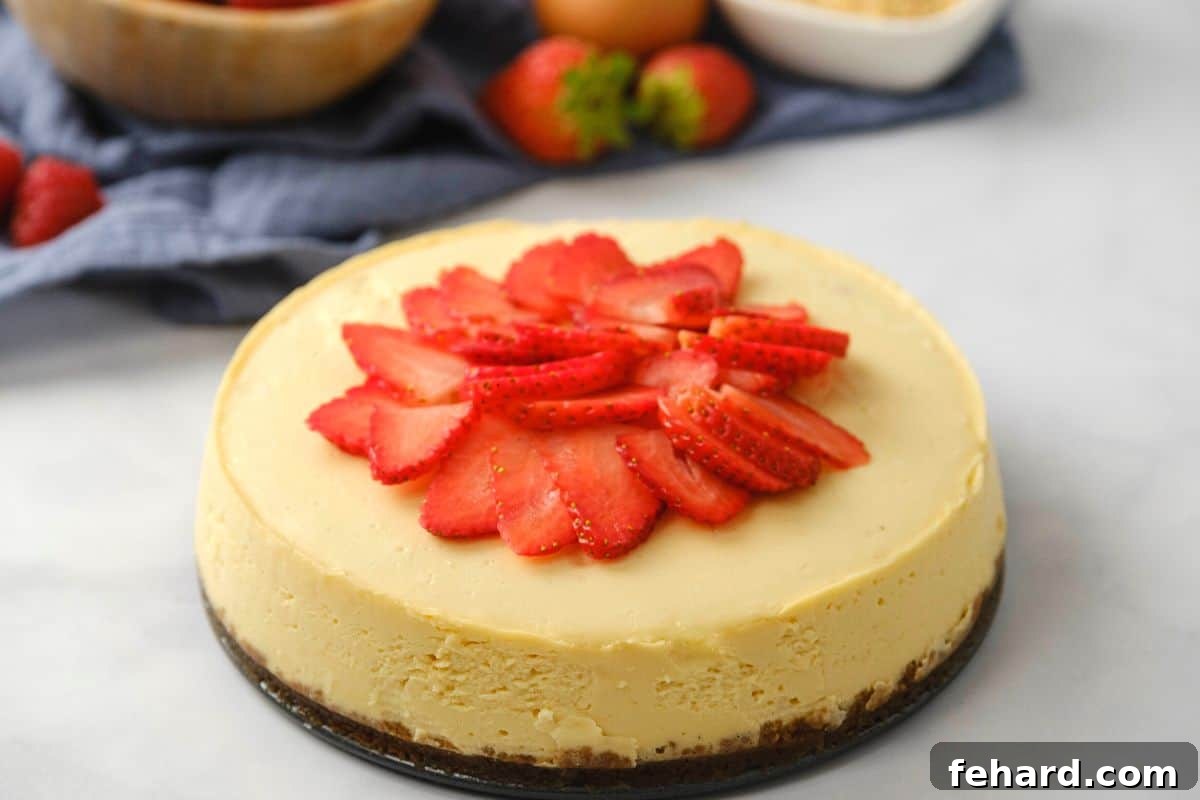 A beautifully sliced Instant Pot Cheesecake generously topped with fresh, vibrant sliced strawberries, ready to be served.