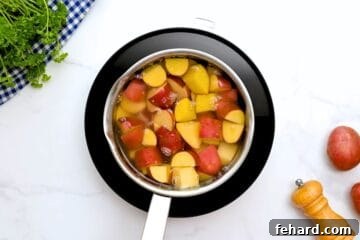 Quartered red potatoes in medium saucepan covered with cold water.