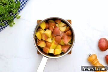 Boiled quartered red potatoes in medium saucepan after being drained from boiling water.