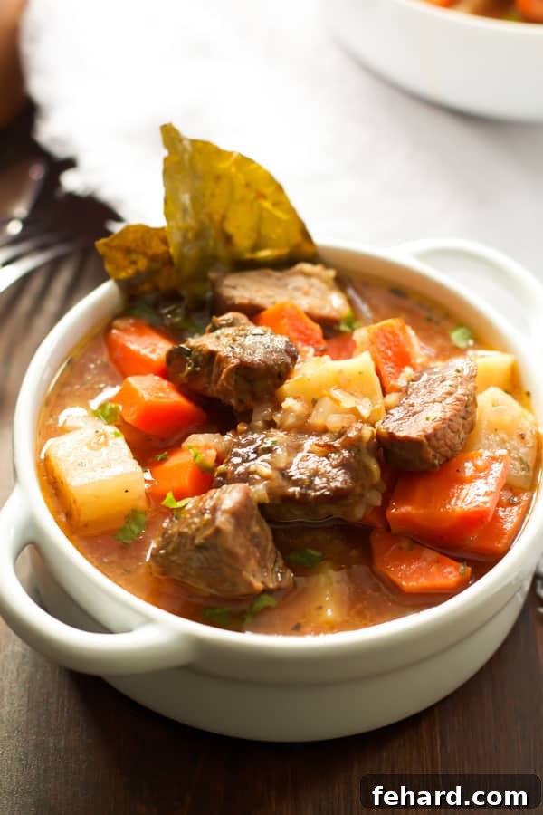 A bowl of healthier slow cooker beef stew, garnished with fresh herbs.