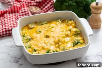 Baked Broccoli Rice Casserole topped with cheese in white casserole dish.