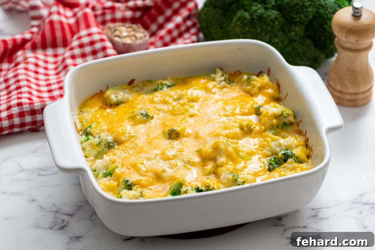 A baked Broccoli Rice Casserole, topped with melted golden cheese, presented in an elegant white casserole dish.