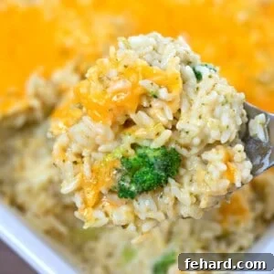 Scoop of homemade broccoli rice casserole with tons of cheese.