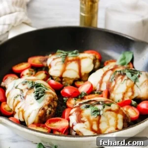 closeup view of baked caprese chicken with melted cheese and fresh basil