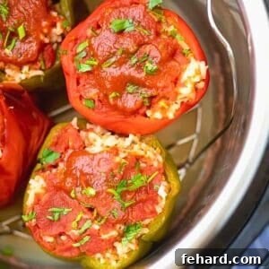 Effortless Instant Pot Stuffed Bell Peppers 3 Stuffed red and green Bell Pepper on trivet inside Instant Pot topped with parsley.