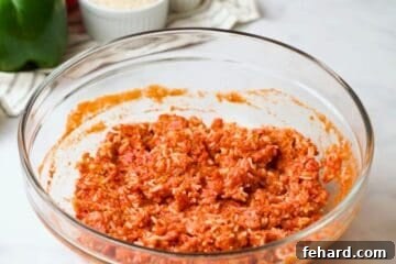 Rice, beef, tomato sauce and seasonings mixed together inside mixing bowl.