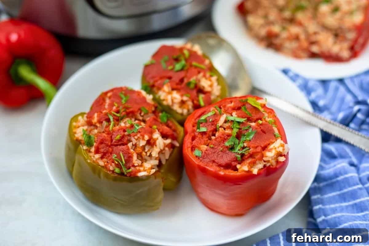Plated Classic Stuffed Peppers Two generously stuffed bell peppers plated alongside a side dish, with the Instant Pot in the background, showcasing a inviting dinner scene.
